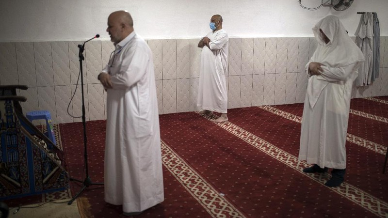 In this photo taken Saturday, April 25, 2020, the family of Bara Tambedou exercises at home after breaking the fast on the first day of the Muslim holy month of Ramadan, in Dakar, Senegal. This year the family is celebrating Ramadan at home, with prohibitions on public gatherings and a dusk-to-dawn curfew in place to curb the spread of the new coronavirus. (AP Photo/Sylvain Cherkaoui)