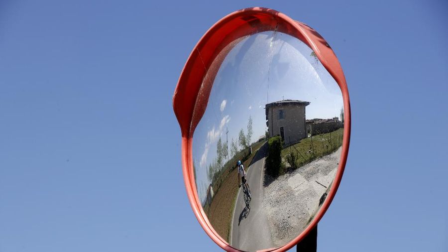 In this image taken on Tuesday, April 14, 2020, Italian professional cyclist Davide Martinelli, collects medicine at a pharmacy to be delivered to residents in Rovato, near Brescia, Northern Italy. There are no fans lining the road. No teammates providing support. And no race to win. Professional cyclist Davide Martinelli has achieved a moral victory, though, by using his bike to help deliver medicine to elderly residents of his hometown in northern Italy during the coronavirus pandemic. (AP Photo/Luca Bruno)