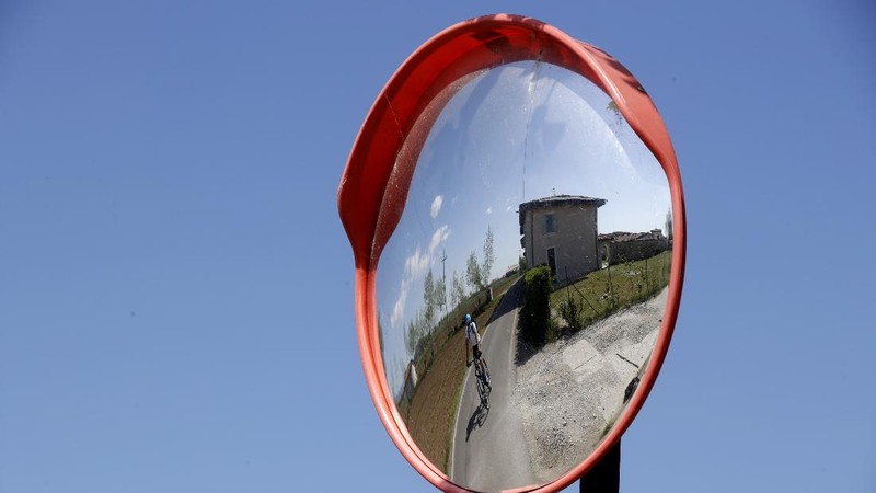 In this image taken on Tuesday, April 14, 2020, Italian professional cyclist Davide Martinelli, collects medicine at a pharmacy to be delivered to residents in Rovato, near Brescia, Northern Italy. There are no fans lining the road. No teammates providing support. And no race to win. Professional cyclist Davide Martinelli has achieved a moral victory, though, by using his bike to help deliver medicine to elderly residents of his hometown in northern Italy during the coronavirus pandemic. (AP Photo/Luca Bruno)