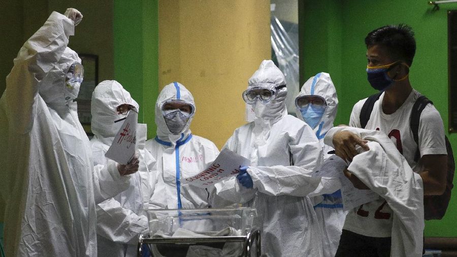 Seorang ayah membawa putranya yang berusia 16 hari dijuluki Kobe, setelah bayinya pulih dari COVID-19 dan dikeluarkan di Rumah Sakit Anak Nasional di kota Quezon, Metro Manila, Filipina AP/Aaron Favila