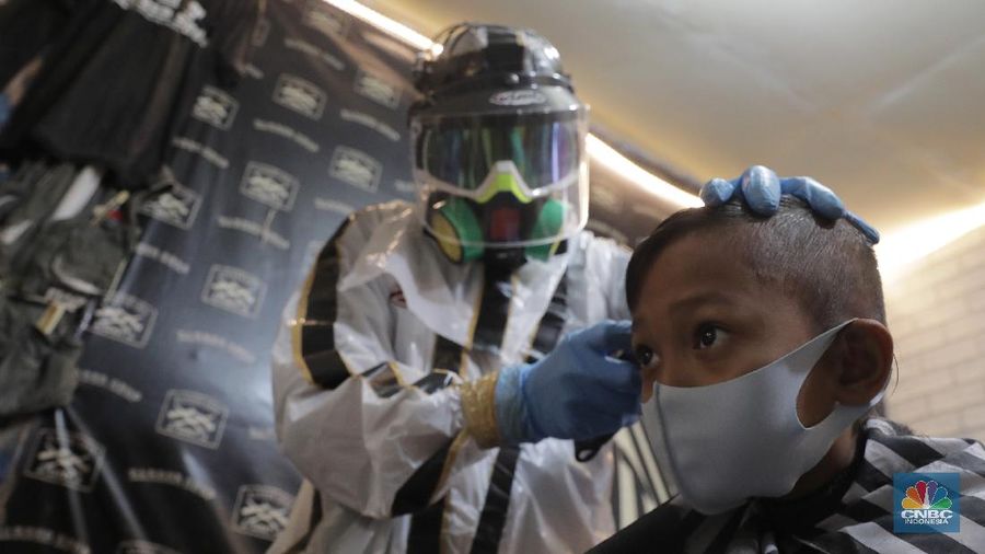Tukang Cukur dengan APD Lengkap demi memotong penularan virus Covid-19 (CNBC Indonesia/Muhammad Sabki)