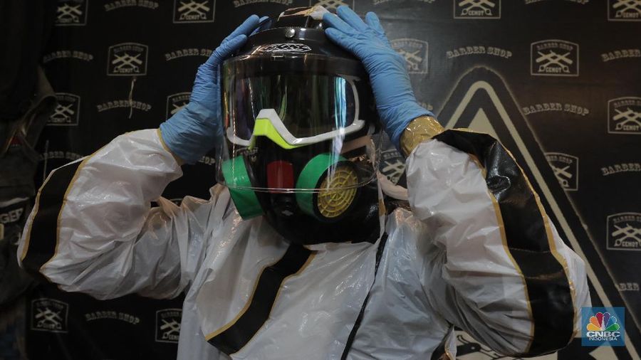 Tukang Cukur dengan APD Lengkap demi memotong penularan virus Covid-19 (CNBC Indonesia/Muhammad Sabki)