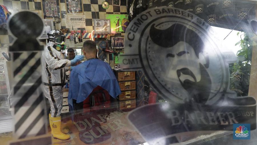 Tukang Cukur dengan APD Lengkap demi memotong penularan virus Covid-19 (CNBC Indonesia/Muhammad Sabki)