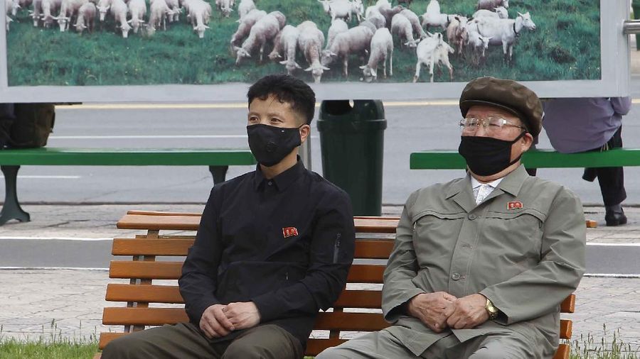 Orang-orang di taman mengenakan topeng menonton berita yang disiarkan di layar raksasa yang memperlihatkan pemimpin Kim Jong Un menghadiri upacara pembukaan Pabrik Pupuk Fosfat Sunchon, Sabtu, 2 Mei. 2020, di Pyongyang, Korea Utara. Un membuat penampilan publik pertamanya dalam 20 hari ketika ia merayakan penyelesaian sebuah pabrik pupuk di dekat Pyongyang, media pemerintah mengatakan Sabtu, mengakhiri ketidakhadiran yang memicu desas-desus global bahwa ia mungkin sakit parah.