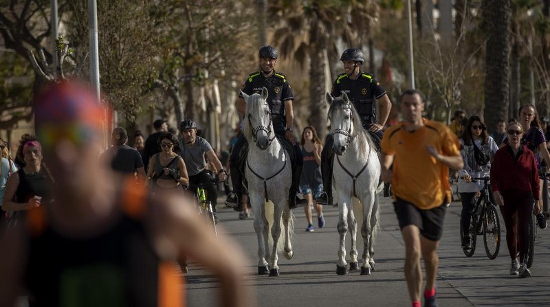 People exercise on a seafront promenade in Barcelona, Spain, Sunday, May 3, 2020. Spaniards have filled the streets of the country to do exercise after seven weeks of confinement to their homes to fight the coronavirus pandemic. People ran, walked, or rode bicycles under a brilliant sunny sky in Barcelona on Saturday, where many flocked to the maritime promenade to get as close as possible to the still off-limits beach. (AP Photo/Emilio Morenatti)