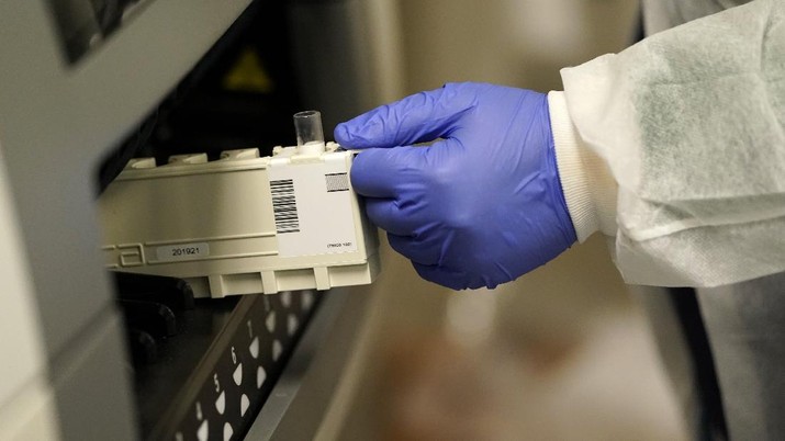 Julie Janke, a medical technologist at Principle Health Systems and SynerGene Laboratory, loads a sample for COVID-19 antibody testing Tuesday, April 28, 2020, in Houston. The company, which opened two new testing locations Tuesday, is now offering a new COVID-19 antibody test developed by Abbott Laboratories. (AP Photo/David J. Phillip)