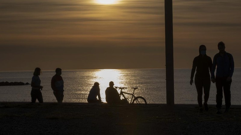 People exercise on a seafront promenade in Barcelona, Spain, Sunday, May 3, 2020. Spaniards have filled the streets of the country to do exercise after seven weeks of confinement to their homes to fight the coronavirus pandemic. People ran, walked, or rode bicycles under a brilliant sunny sky in Barcelona on Saturday, where many flocked to the maritime promenade to get as close as possible to the still off-limits beach. (AP Photo/Emilio Morenatti)