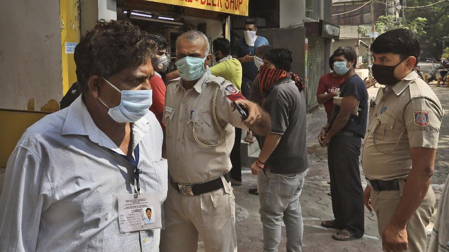 Indians line up to buy liquor outside one of the liquor shops which was reopened Monday after six weeks lockdown on the outskirts of New Delhi, India, Monday, May 4, 2020. India's six-week coronavirus lockdown, which was supposed to end on Monday, has been extended for another two weeks, with a few relaxations. Locking down the country's 1.3 billion people has slowed down the spread of the virus, but has come at the enormous cost of upending lives and millions of lost jobs. (AP Photo/Altaf Qadri)