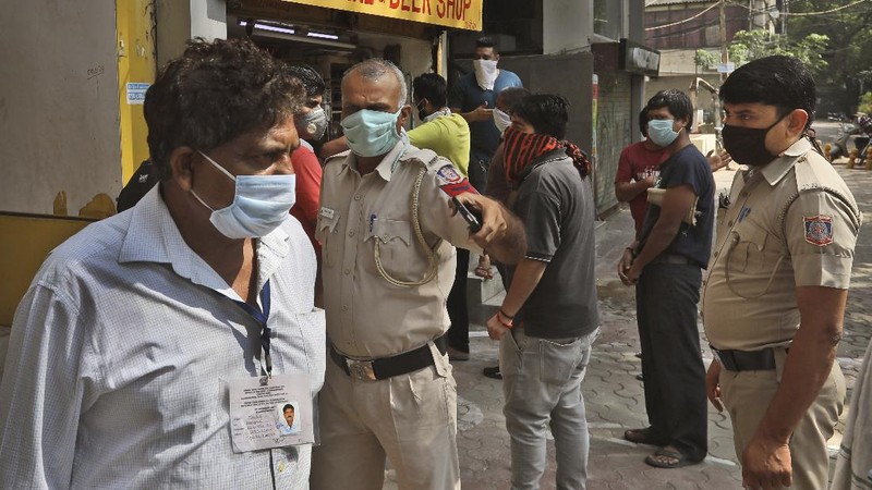 Indians line up to buy liquor outside one of the liquor shops which was reopened Monday after six weeks lockdown on the outskirts of New Delhi, India, Monday, May 4, 2020. India's six-week coronavirus lockdown, which was supposed to end on Monday, has been extended for another two weeks, with a few relaxations. Locking down the country's 1.3 billion people has slowed down the spread of the virus, but has come at the enormous cost of upending lives and millions of lost jobs. (AP Photo/Altaf Qadri)