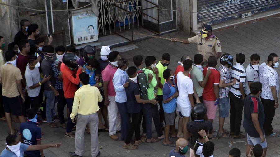 Indians line up to buy liquor outside one of the liquor shops which was reopened Monday after six weeks lockdown on the outskirts of New Delhi, India, Monday, May 4, 2020. India's six-week coronavirus lockdown, which was supposed to end on Monday, has been extended for another two weeks, with a few relaxations. Locking down the country's 1.3 billion people has slowed down the spread of the virus, but has come at the enormous cost of upending lives and millions of lost jobs. (AP Photo/Altaf Qadri)