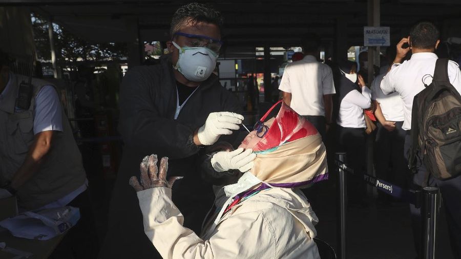 A health worker conducts a swab test for the new coronavirus in Bekasi on the outskirts of Jakarta, Indonesia, Tuesday, May 5, 2020. (AP Photo/Achmad Ibrahim)