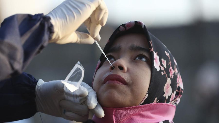 A health worker conducts a swab test for the new coronavirus in Bekasi on the outskirts of Jakarta, Indonesia, Tuesday, May 5, 2020. (AP Photo/Achmad Ibrahim)