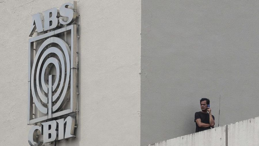 A man wearing a mask passes by the headquarters of broadcast network ABS-CBN Corp. on Wednesday May 6, 2020 in Manila, Philippines. Philippine church and business leaders expressed alarm Wednesday over a government agency’s shutdown of the country’s largest TV and radio network, which has been a major provider of news on the coronavirus pandemic. (AP Photo/Aaron Favila)