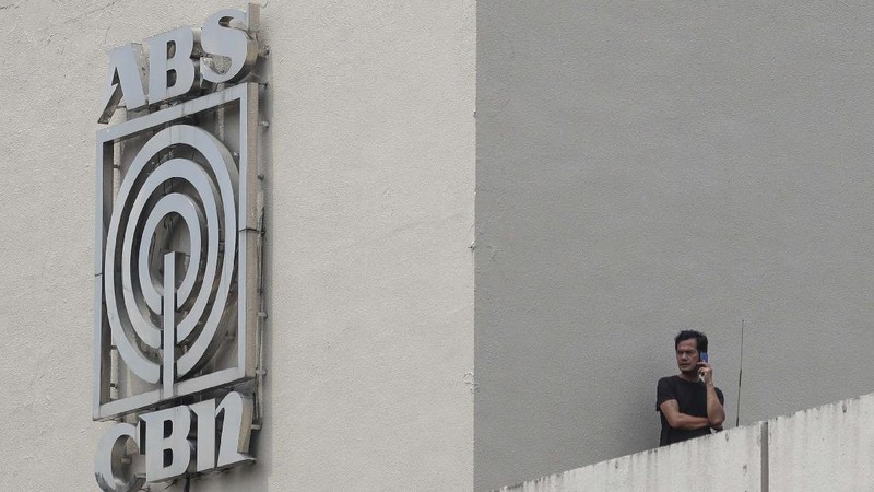 A man wearing a mask passes by the headquarters of broadcast network ABS-CBN Corp. on Wednesday May 6, 2020 in Manila, Philippines. Philippine church and business leaders expressed alarm Wednesday over a government agency’s shutdown of the country’s largest TV and radio network, which has been a major provider of news on the coronavirus pandemic. (AP Photo/Aaron Favila)