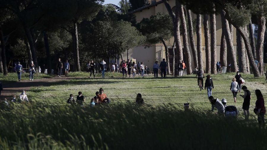 People gather inside Rome's Villa Pamphili park as it reopened after several weeks of closure, part of nationwide limited easing of some lockdown restrictions, on Monday, May 4, 2020. Italy began stirring again Monday after a two-month coronavirus shutdown, with 4.4 million Italians able to return to work and restrictions on movement eased in the first European country to lock down in a bid to stem COVID-19 infections.  (AP Photo/Alessandra Tarantino)