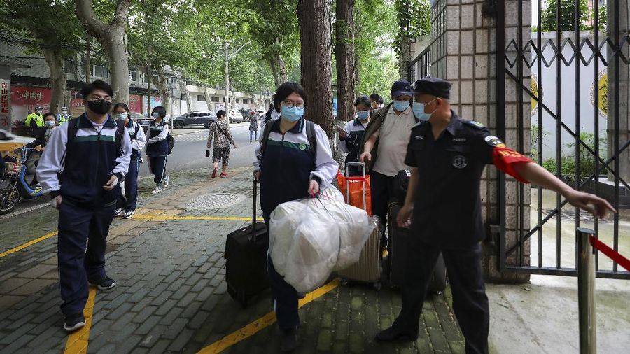 Students wearing protective face masks to help curb the spread of the new coronavirus walk in social distancing as they arrive to a high school in Wuhan in central China's Hubei province, Wednesday, May 6, 2020. Senior students returned to classes on Wednesday in the central Chinese city of Wuhan, the epicenter of the coronavirus pandemic, after no new cases or deaths were reported from the outbreak that had prompted a 76-day quarantine in the city of 11 million. (Chinatopix via AP)