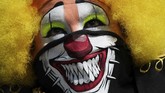 Visual yang kuat ini salah satu dimanfaatkan oleh seorang badut di area National Palace, Meksiko. Masker bergambar gigi badut digunakannya untuk menghibur masyarakat. (AP Photo/Fernando Llano)