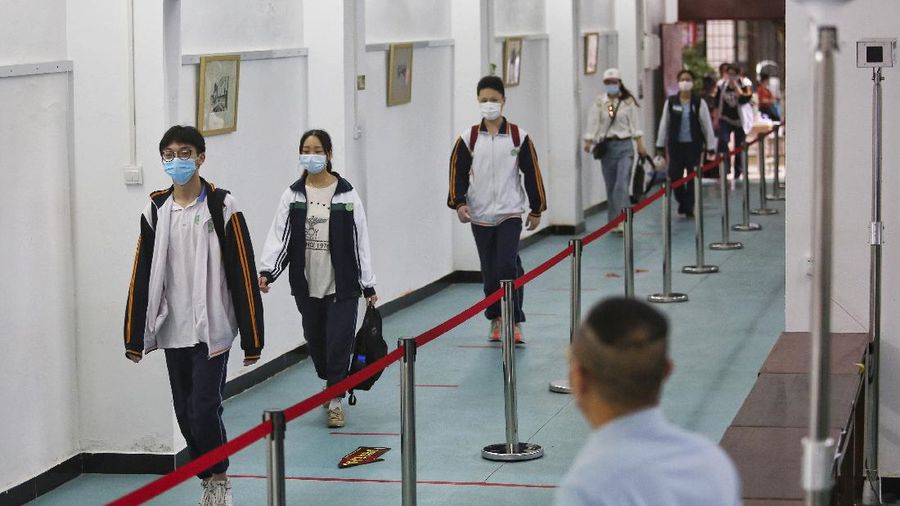 Students wearing protective face masks to help curb the spread of the new coronavirus walk in social distancing as they arrive to a high school in Wuhan in central China's Hubei province, Wednesday, May 6, 2020. Senior students returned to classes on Wednesday in the central Chinese city of Wuhan, the epicenter of the coronavirus pandemic, after no new cases or deaths were reported from the outbreak that had prompted a 76-day quarantine in the city of 11 million. (Chinatopix via AP)