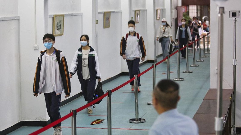 Students wearing protective face masks to help curb the spread of the new coronavirus walk in social distancing as they arrive to a high school in Wuhan in central China's Hubei province, Wednesday, May 6, 2020. Senior students returned to classes on Wednesday in the central Chinese city of Wuhan, the epicenter of the coronavirus pandemic, after no new cases or deaths were reported from the outbreak that had prompted a 76-day quarantine in the city of 11 million. (Chinatopix via AP)