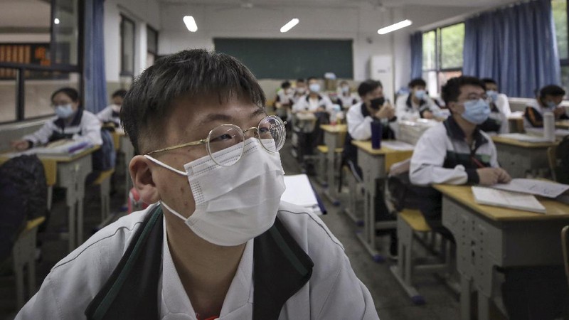 Students wearing protective face masks to help curb the spread of the new coronavirus walk in social distancing as they arrive to a high school in Wuhan in central China's Hubei province, Wednesday, May 6, 2020. Senior students returned to classes on Wednesday in the central Chinese city of Wuhan, the epicenter of the coronavirus pandemic, after no new cases or deaths were reported from the outbreak that had prompted a 76-day quarantine in the city of 11 million. (Chinatopix via AP)