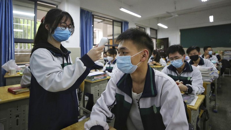 Students wearing protective face masks to help curb the spread of the new coronavirus walk in social distancing as they arrive to a high school in Wuhan in central China's Hubei province, Wednesday, May 6, 2020. Senior students returned to classes on Wednesday in the central Chinese city of Wuhan, the epicenter of the coronavirus pandemic, after no new cases or deaths were reported from the outbreak that had prompted a 76-day quarantine in the city of 11 million. (Chinatopix via AP)