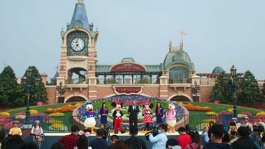 Visitors, wearing face masks, wait to enter the Disneyland theme park in Shanghai as it reopened, Monday, May 11, 2020. Visits will be limited initially and must be booked in advance, and the company said it will increase cleaning and require social distancing in lines for the various attractions. With warmer weather and new coronavirus cases and deaths falling to near-zero, China has been reopening tourist sites such as the Great Wall and the Forbidden City palace complex in Beijing.(AP Photo/Sam McNeil)