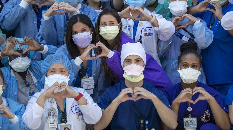 Mount Sinai Queens nurses make a heart sign as they pose for a photo to celebrate the last day of National Nurses Week 2020, Tuesday, May 12, 2020, in the Astoria neighborhood of the Queens borough of New York.