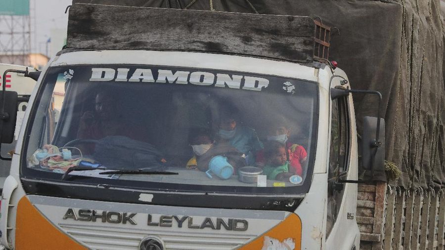 A migrant worker from Chhattisgarh state helps a child climb onto a truck to travel to their villages hundreds of miles away, during a nationwide lockdown to curb the spread of new coronavirus on the outskirts of Hyderabad, India, Tuesday, May 12, 2020. The lockdown that began March 25 sent an exodus of workers from its huge informal sector fleeing the cities to their ancestral homes in the countryside. Economists say unemployment reached 24.7% this week. (AP Photo/Mahesh Kumar A)