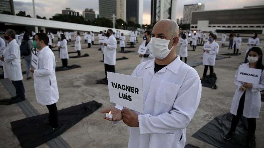 Perawat berkumpul memegang plakat dengan nama-nama rekan mereka yang meninggal dalam perjuangan mereka melawan pandemi coronavirus (AP/Eraldo Peres)