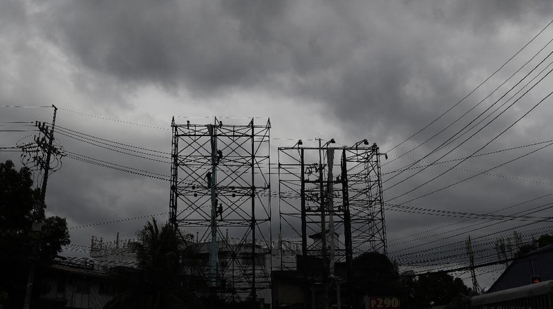 Dark clouds envelop the skies as workers fold a billboard to prepare for the coming of typhoon Vongfong in Manila, Philippines Thursday May, 14, 2020. The first typhoon to hit the country this year roared toward the eastern Philippines on Thursday as authorities work to evacuate tens of thousands of people while avoiding overcrowding in shelters that could spread the coronavirus. (AP Photo/Aaron Favila)