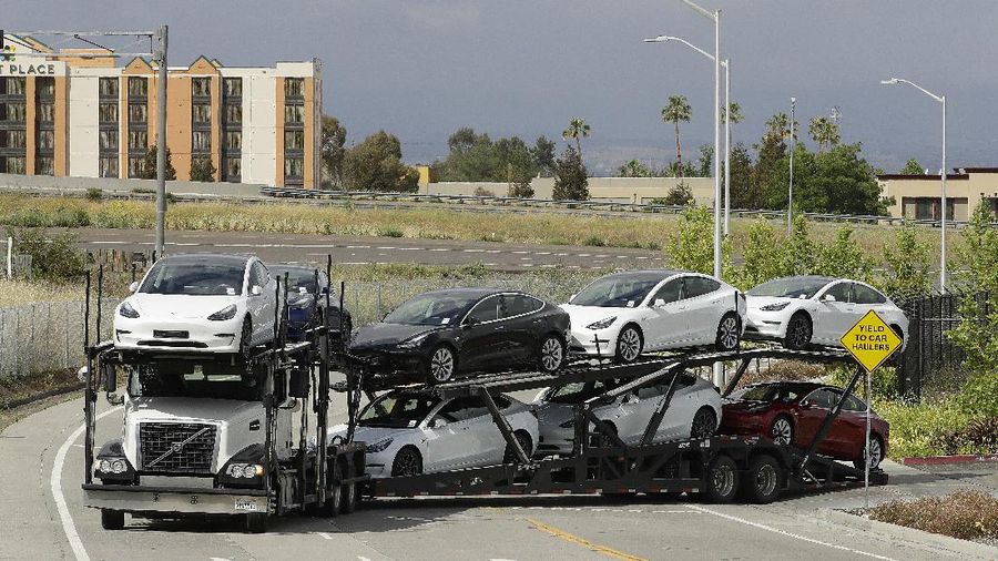A truck loaded with Tesla cars departs the Tesla plant Tuesday, May 12, 2020, in Fremont, Calif. Tesla CEO Elon Musk has emerged as a champion of defying stay-home orders intended to stop the coronavirus from spreading, picking up support as well as critics on social media. Among supporters was President Donald Trump, who on Tuesday tweeted that Tesla's San Francisco Bay Area factory should be allowed to open despite health department orders to stay closed except for basic operations. (AP Photo/Ben Margot)