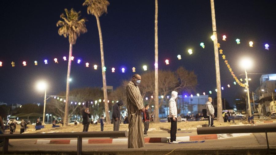 Muslim men keep social distancing as they pray after breaking their daytime fast, at a parking lot as mosques remain closed to prevent the spread of coronavirus pandemic during the holy month of Ramadan, in the mixed Arab Jewish city of Jaffa, near Tel Aviv, Israel, Sunday, May 10, 2020. (AP Photo/Oded Balilty)