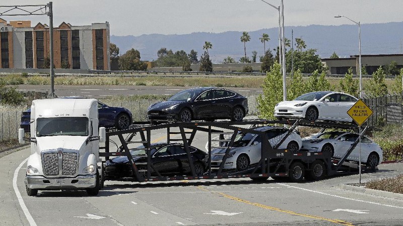 A truck loaded with Tesla cars departs the Tesla plant Tuesday, May 12, 2020, in Fremont, Calif. Tesla CEO Elon Musk has emerged as a champion of defying stay-home orders intended to stop the coronavirus from spreading, picking up support as well as critics on social media. Among supporters was President Donald Trump, who on Tuesday tweeted that Tesla's San Francisco Bay Area factory should be allowed to open despite health department orders to stay closed except for basic operations. (AP Photo/Ben Margot)