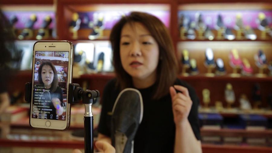 In this April 27, 2020, photo, Song Huiyan prepares her fashion dresses for the live-streaming at her clothing shop in Beijing. Retailers in China are embracing livestreaming as a sales channel amid a Chinese “shoppertainment” boom accelerated during the COVID-19 pandemic. Via livestreaming, retailers can interact with customers in real time, while customers make purchases directly in the stream. (AP Photo/Andy Wong)