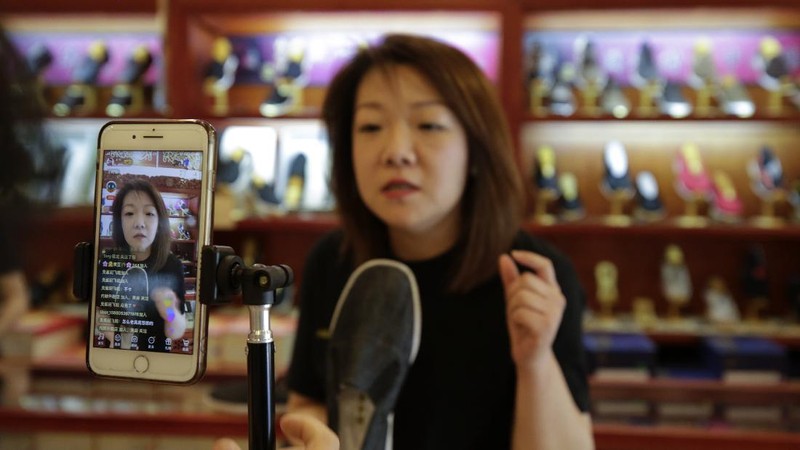 In this April 27, 2020, photo, Song Huiyan prepares her fashion dresses for the live-streaming at her clothing shop in Beijing. Retailers in China are embracing livestreaming as a sales channel amid a Chinese “shoppertainment” boom accelerated during the COVID-19 pandemic. Via livestreaming, retailers can interact with customers in real time, while customers make purchases directly in the stream. (AP Photo/Andy Wong)