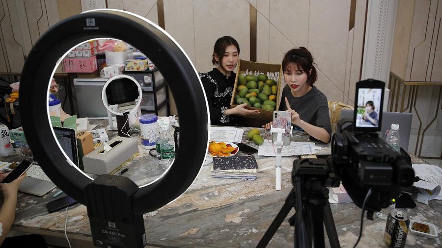 In this April 27, 2020, photo, Song Huiyan prepares her fashion dresses for the live-streaming at her clothing shop in Beijing. Retailers in China are embracing livestreaming as a sales channel amid a Chinese “shoppertainment” boom accelerated during the COVID-19 pandemic. Via livestreaming, retailers can interact with customers in real time, while customers make purchases directly in the stream. (AP Photo/Andy Wong)