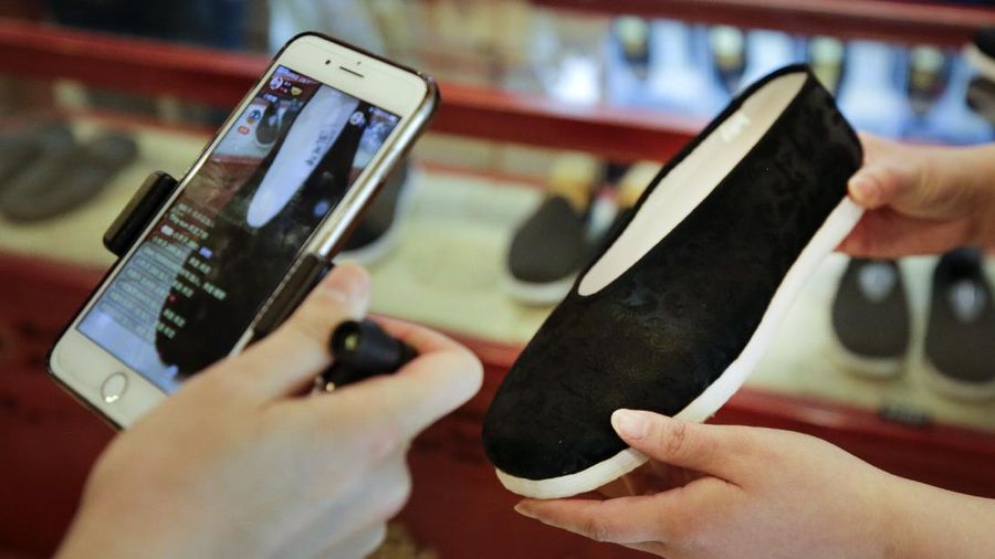 In this April 27, 2020, photo, Song Huiyan prepares her fashion dresses for the live-streaming at her clothing shop in Beijing. Retailers in China are embracing livestreaming as a sales channel amid a Chinese “shoppertainment” boom accelerated during the COVID-19 pandemic. Via livestreaming, retailers can interact with customers in real time, while customers make purchases directly in the stream. (AP Photo/Andy Wong)