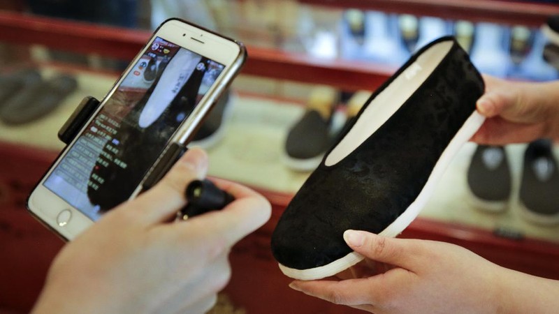 In this April 27, 2020, photo, Song Huiyan prepares her fashion dresses for the live-streaming at her clothing shop in Beijing. Retailers in China are embracing livestreaming as a sales channel amid a Chinese “shoppertainment” boom accelerated during the COVID-19 pandemic. Via livestreaming, retailers can interact with customers in real time, while customers make purchases directly in the stream. (AP Photo/Andy Wong)