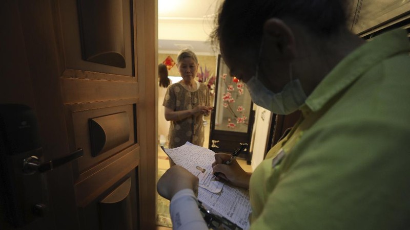 A medical worker takes a swab from a resident for the coronavirus test during home visits in Wuhan the epicenter of China's coronavirus outbreak in central China's Hubei province, Thursday, May 14, 2020. Some residential compounds in Wuhan have begun testing inhabitants for the coronavirus as a program to test everyone in the Chinese city of 11 million people in 10 days got underway. (Chinatopix via AP)