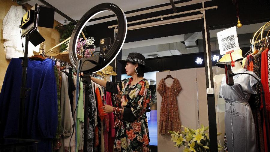 In this April 27, 2020, photo, Song Huiyan prepares her fashion dresses for the live-streaming at her clothing shop in Beijing. Retailers in China are embracing livestreaming as a sales channel amid a Chinese “shoppertainment” boom accelerated during the COVID-19 pandemic. Via livestreaming, retailers can interact with customers in real time, while customers make purchases directly in the stream. (AP Photo/Andy Wong)