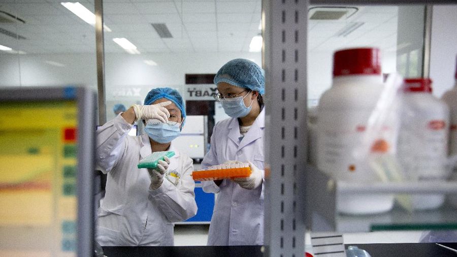 Employees work in a research and development lab of Beijing Applied Biological Technologies, a firm which is developing COVID-19 molecular diagnostic test kits, during a government organized tour for journalists in Beijing, Thursday, May 14, 2020. China reported three new coronavirus cases Thursday while moving to reopen for business and schools. (AP Photo/Mark Schiefelbein)