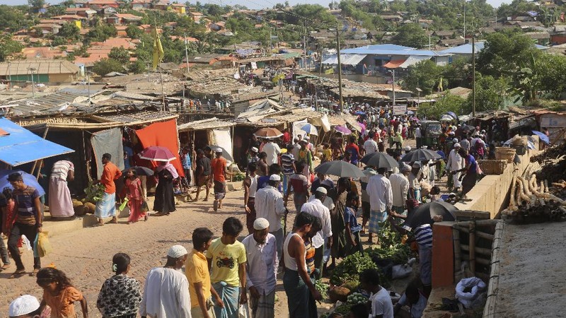 In this Friday, May 15, 2020, photo, a security officer makes announcements on a megaphone for people to observe social distancing at Kutupalong Rohingya camp bazar in Cox’s Bazar, Bangladesh. The first coronavirus case has been confirmed in the crowded camps for Rohingya refugees in southern Bangladesh, where more than 1 million are taking shelter. The infected Rohingya and a local Bangladeshi who lives in the Cox's Bazar district who also tested positive have been isolated, Mahbub Alam Talukder, the country’s refugee commissioner, said Thursday. (AP Photo/Suzauddin Rubel)
