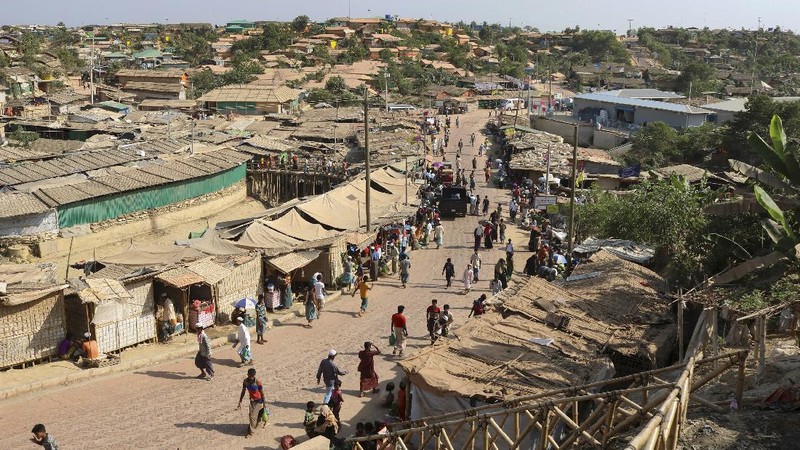 In this Friday, May 15, 2020, photo, a security officer makes announcements on a megaphone for people to observe social distancing at Kutupalong Rohingya camp bazar in Cox’s Bazar, Bangladesh. The first coronavirus case has been confirmed in the crowded camps for Rohingya refugees in southern Bangladesh, where more than 1 million are taking shelter. The infected Rohingya and a local Bangladeshi who lives in the Cox's Bazar district who also tested positive have been isolated, Mahbub Alam Talukder, the country’s refugee commissioner, said Thursday. (AP Photo/Suzauddin Rubel)