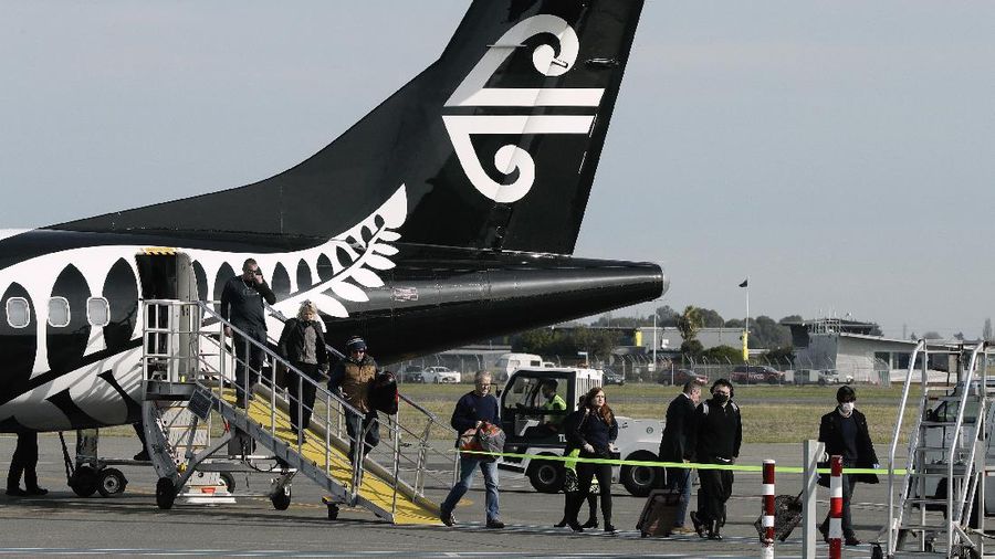 Passengers disembark from their flight at Christchurch Airport in Christchurch, New Zealand, Thursday, May 14, 2020. New Zealand lifted most of its remaining lockdown restrictions from midnight Wednesday as the country prepares for a new normal. Malls, retail stores and restaurants are all reopening Thursday in the South Pacific nation of 5 million, and many people are returning to their workplaces. (AP Photo/Mark Baker)