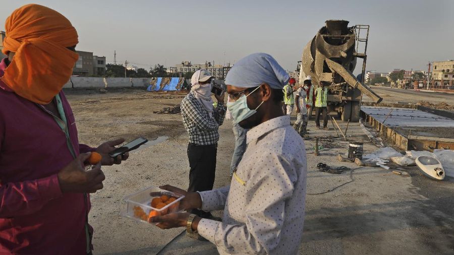 Workers on a highway construction site return after day's work, in Ghaziabad, on the outskirts of New Delhi, India, May 16, 2020. India's lockdown, imposed March 25, is set to at least partially end May 18. Some restrictions on manufacturing, agriculture and self-employment were lifted May 4 to ease the burden on the poor and informal sector workers who comprise the majority of India's workforce. (AP Photo/Manish Swarup)