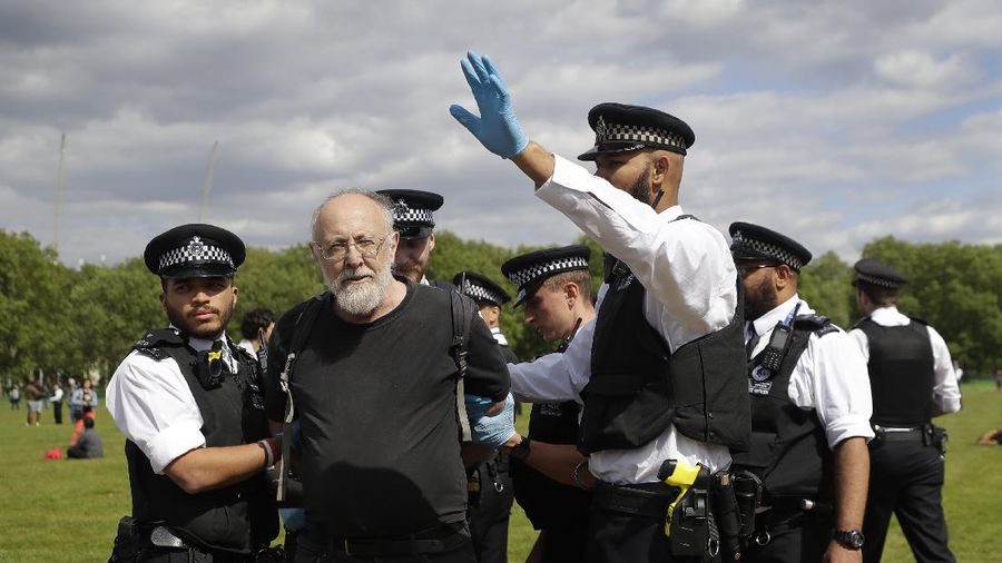 A man is arrested during a mass gathering protest organised by the group called 'UK Freedom Movement', in Hyde Park in London as the country is in lockdown to help stop the spread of coronavirus, Saturday, May 16, 2020. The group claims that the coronavirus lockdown is illegal. (AP Photo/Kirsty Wigglesworth)