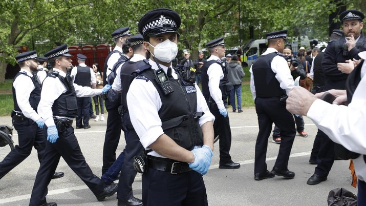 Demo Inggris di Tengah Pandemi (AP/Kirsty Wigglesworth) A man is arrested during a mass gathering protest organised by the group called 'UK Freedom Movement', in Hyde Park in London as the country is in lockdown to help stop the spread of coronavirus, Saturday, May 16, 2020. The group claims that the coronavirus lockdown is illegal. (AP Photo/Kirsty Wigglesworth)
