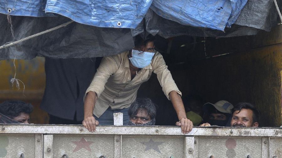 Migrant workers sit inside a truck, after they were stopped and directed towards a temporary shelter to register for free travel on a train, during lockdown to prevent the spread of new coronavirus on the outskirts of Hyderabad, India, Saturday, May 16, 2020. Tens of thousands of migrant laborers have been returning from big cities to their villages after losing jobs because of a countrywide lockdown imposed in late March to contain the spread of the coronavirus. (AP Photo/Mahesh Kumar A.)