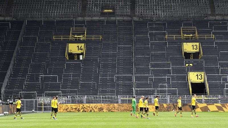 Dortmund players enter the pitch for the German Bundesliga soccer match between Borussia Dortmund and Schalke 04 in Dortmund, Germany, Saturday, May 16, 2020. The German Bundesliga becomes the world's first major soccer league to resume after a two-month suspension because of the coronavirus pandemic. (AP Photo/Martin Meissner, Pool)