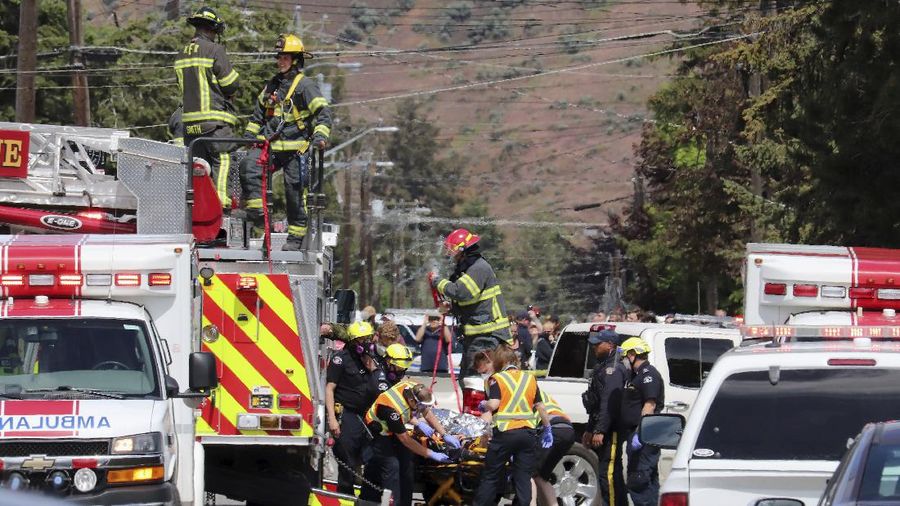 First responders attend to a person on a rooftop at the scene of a crash involving a Canadian Forces Snowbirds airplane in Kamloops, British Columbia, Sunday, May 17, 2020. (Brendan Kergin/Castanet Kamloops/The Canadian Press via AP)